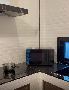 a kitchen with a black counter top with a microwave at LOMA Pool Villa in Ban Nong Thale