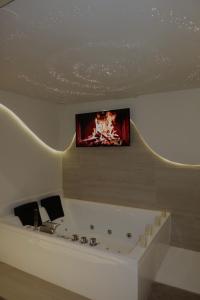 ein Zimmer mit einem Fernseher an der Decke in der Unterkunft SPA PRIVATIF - LOVE ROOM LUXE - PROCHE DISNEY in Marles-en-Brie