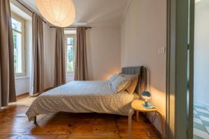 a bedroom with a bed and a table with a lamp at Villa Le Camelie - Charme & Relax in Pinerolo