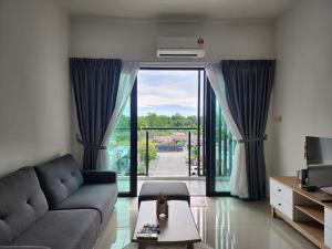 a living room with a couch and a large window at Serene Stay at Kuching City in Kuching