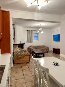 a kitchen and living room with a table and a couch at Oikos Corfu in Alepou +16 photos