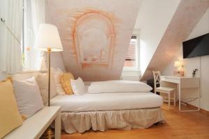 a living room with a white couch and a table at Hotel Stadtherz in Burgwedel