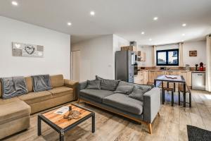 a living room with a couch and a kitchen at Aux pieds des pistes - Appt B in Ax-les-Thermes