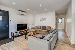 a living room with a couch and a tv at Aux pieds des pistes - Appt B in Ax-les-Thermes