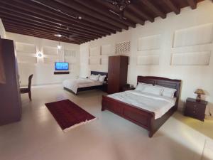 ein Schlafzimmer mit zwei Betten und einem Flachbildfernseher in der Unterkunft Hyba Heritage Guest House in Dubai