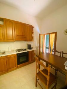 cocina con armarios de madera, mesa y fogones en Casa Dona, en San Miniato