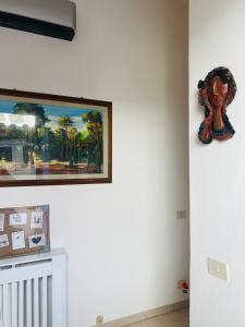 Una pared con una pintura y una escultura. en Casa Dona, en San Miniato