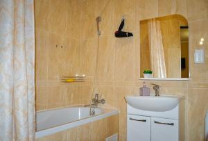un bagno con vasca, lavandino e specchio di Центр Новострой Новая большая однокомнатная квартира со всеми удобствами a Mukačevo Altre 20 foto
