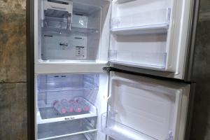 an open refrigerator with its door open and some food inside at City House Don Mueang Airport Bangkok in Don Muang Airport