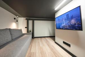 a living room with a couch and a flat screen tv at Nomad Boutique Hostel - Women Only, Self Check-In, City Centre in Tallinn
