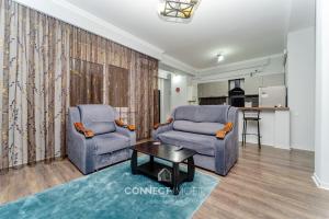 キシナウにあるGreat studio apartmentの椅子2脚とテーブルのあるリビングルーム