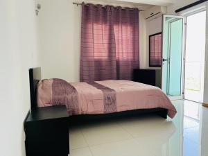a bedroom with a bed with a purple curtain at Douceur de Vie in Praia