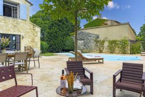 a patio with chairs and a table and a pool at Mas du Micocoulier in Paradou