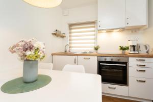a kitchen with a vase of flowers on a table at Die Böttgerei Dünenkeiler in Dahme