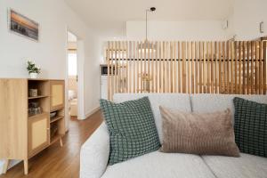 a living room with a white couch with pillows at Die Böttgerei Dünenkeiler in Dahme