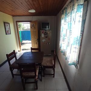 a dining room with a table and chairs and a refrigerator at Complejo Corrientes Dpto 3 in Jesús María
