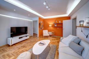 Una sala de estar con un sofá y un televisor. en Marasca Belgrade - Cozy, Chic & Nomad-friendly Flat in Downtown, en Belgrado