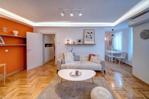 una sala de estar con un sofá y una mesa en Marasca Belgrade - Cozy, Chic & Nomad-friendly Flat in Downtown, en Belgrado