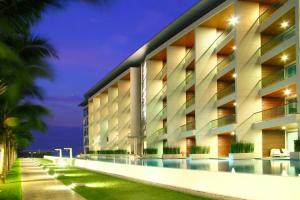 北芭堤雅Beachfront Luxe with Pool Access and Terrace的一座大型建筑,前面设有一个游泳池