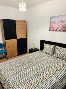a bedroom with a bed with a striped comforter at Apartmani Summer in Kolan