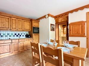 a kitchen with a wooden table with chairs and a dining room at L’Arolles Spa, Calme & Vue Montagne in Champagny-en-Vanoise