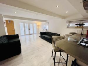 a living room with a couch and a table at Unique Modern Studio Apartment in Motherwell