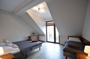 a bedroom with a bed and a couch and a window at Pensjonat Sunrise in Rewal