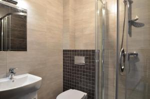 a bathroom with a shower and a toilet and a sink at Pensjonat Sunrise in Rewal +40 photos
