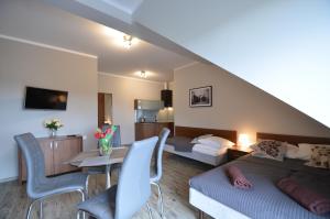 a bedroom with a bed and a table and chairs at Pensjonat Sunrise in Rewal