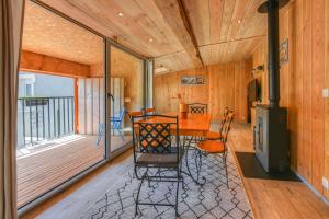 a room with a table and chairs and a balcony at Maison - Le pic du midi in Roquefeuil
