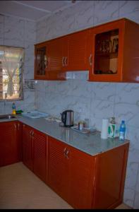 a kitchen with orange cabinets and a counter top at Mama Maya peaceful home in Moshi +12 photos