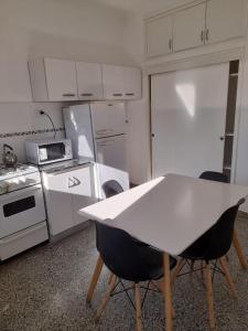 a kitchen with a white table and chairs in it at Depto Centrico en Planta Alta in Bahía Blanca