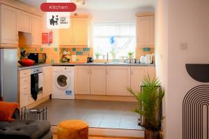 a kitchen with white cabinets and a washer and dryer at 2 Bedroom Apartment By Littlepiggyrentals Short Lets & Serviced Accommodation Stansted Mountfitchet Near Stansted Airport in Stansted Mountfitchet