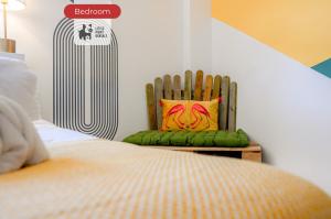 a bedroom with a wooden chair with a colorful pillow at 2 Bedroom Apartment By Littlepiggyrentals Short Lets & Serviced Accommodation Stansted Mountfitchet Near Stansted Airport in Stansted Mountfitchet