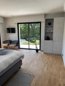 a bedroom with a bed and a large sliding glass door at B and B 46 in Tour-de-Faure