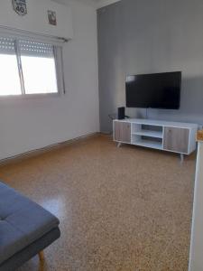 a living room with a flat screen tv and a couch at Depto Centrico en Planta Alta in Bahía Blanca