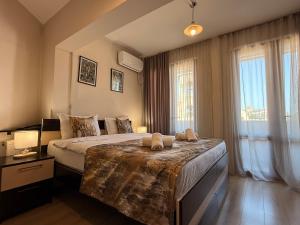 a bedroom with a large bed and a large window at Liva Hotel in Tbilisi City