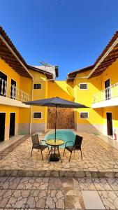 a patio with a table and chairs and an umbrella at Pousada Casa do Mar Inn Paraty "NOVIDADE" in Paraty