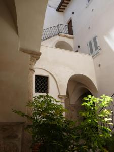 un edificio con un arco y un balcón en Casa Piccolomini, en Ascoli Piceno