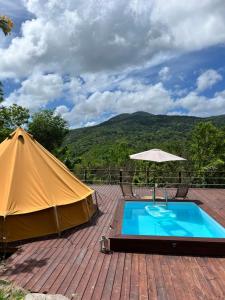 黑角Pop Lodge的一个帐篷、一个游泳池和一把遮阳伞