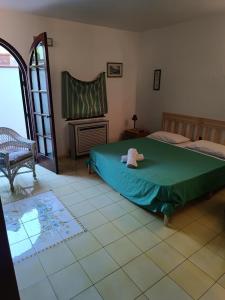 a bedroom with a green bed and a fireplace at Villa Calù in Casamicciola Terme