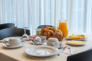 Una mesa con platos de comida y una canasta de comida. en Hotel Azinheira by RIDAN Hotels, en Fátima