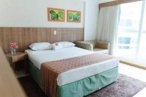 巴西利亚SM1116 Apart Hotel em andar alto região central的有一张大床和一扇窗户的酒店房间