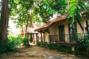 a small house with a porch and a tree at Pasir Hor Villa in Kota Bharu