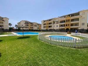 ein Swimmingpool in einem Hof neben einigen Gebäuden in der Unterkunft Apartamento La Laguna in Chipiona