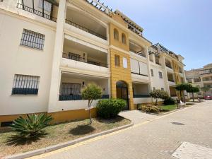 ein Apartmenthaus mit gelber Tür auf einer Straße in der Unterkunft Apartamento La Laguna in Chipiona