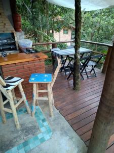 a wooden deck with tables and chairs on it at Casa da Lua Estrela in Visconde De Maua