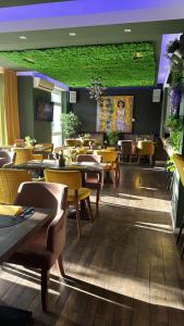 a restaurant with tables and chairs and a green wall at Boutique Hotel VIVA CREATIVO in Hannover