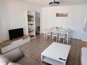 a living room with a tv and a table and chairs at Apartamento de 3 habitaciones cercano a la playa in Tarifa