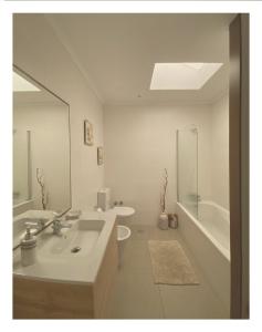 a bathroom with a sink and a tub and a mirror at Casa Physalis in Ponta Delgada +114 photos